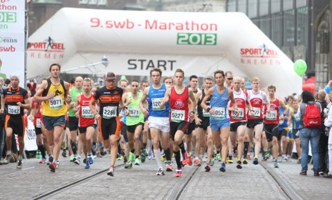 Teilnehmer eines Marathons laufen am Start los. Teilnehmer eines Marathons laufen am Start los.